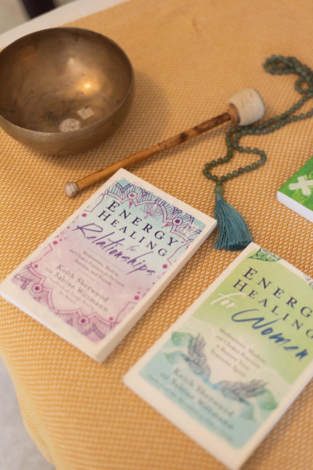 Klangschale, Mala und Bücher auf einer warmen Decke